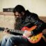 man playing the guitar feat