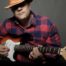 man holding the electric guitar feat
