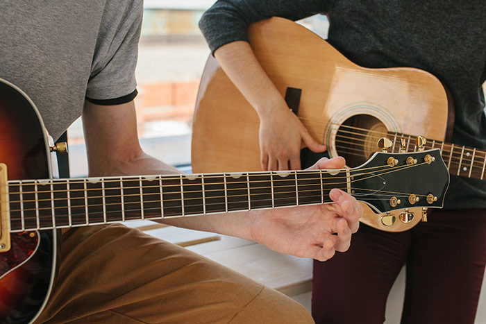 Man learning guitar from his teacher