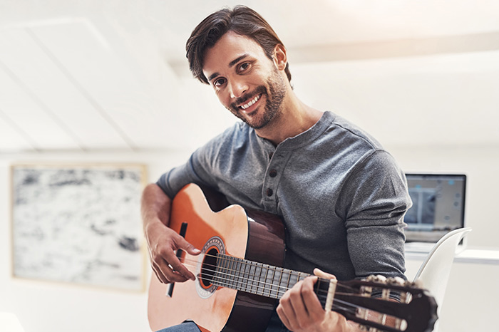 Man smiling and staring with guitar