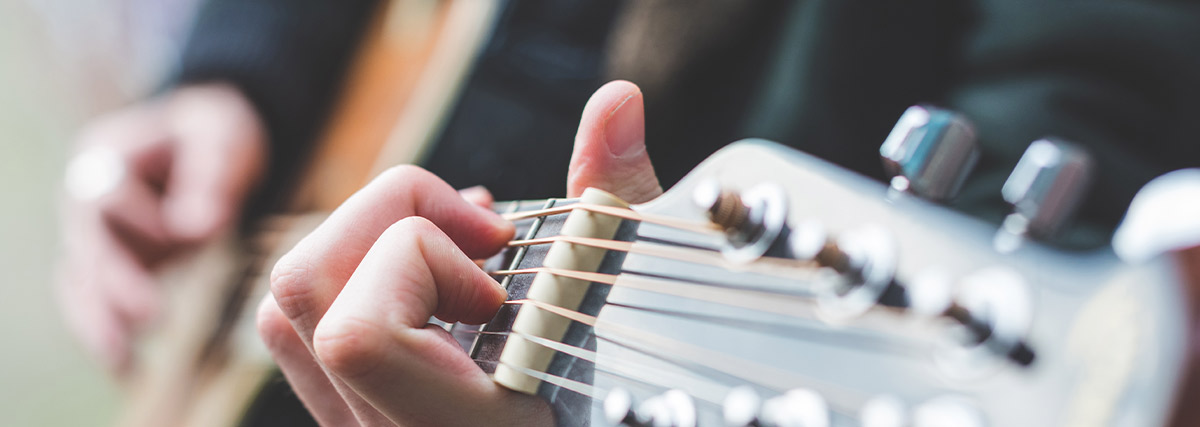 Man fingers playing guitar