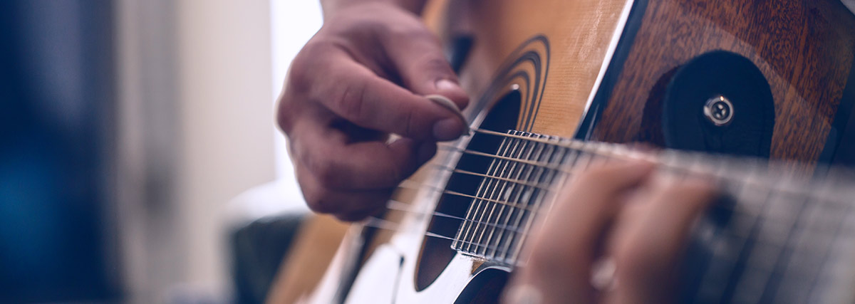 Man hand playing acoustic guitar