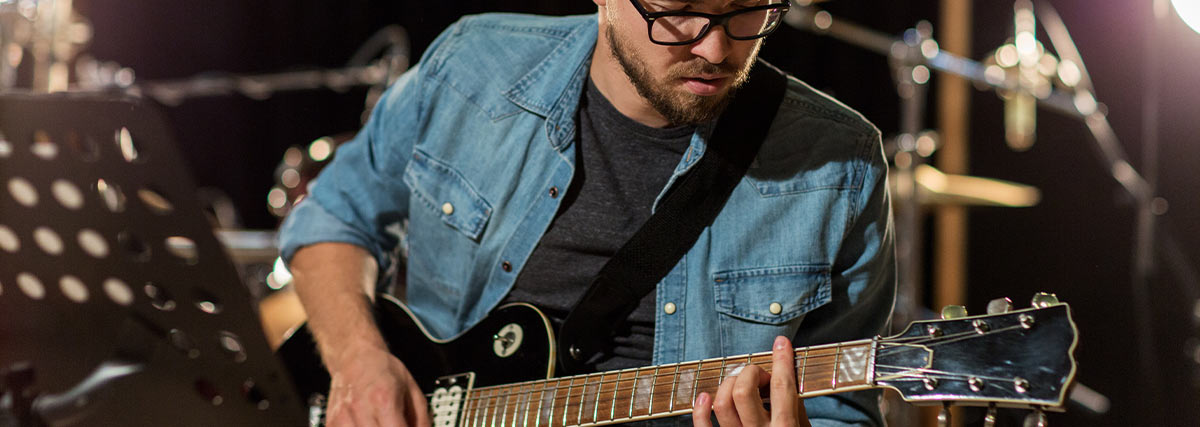 Man with glasses playing guitar