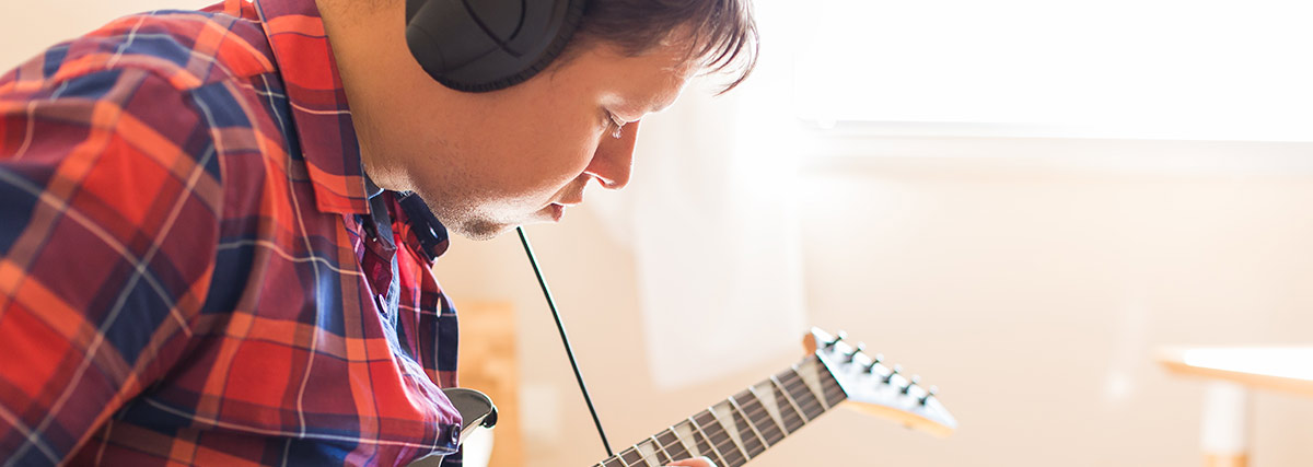 Man with headphone playing guitar