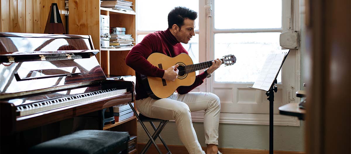 Adult guitar student practising acoustic guitar