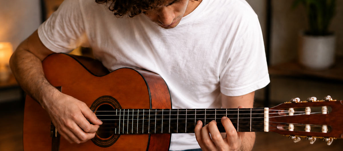 Guitarist practising classical guitar technique and finger placement at home