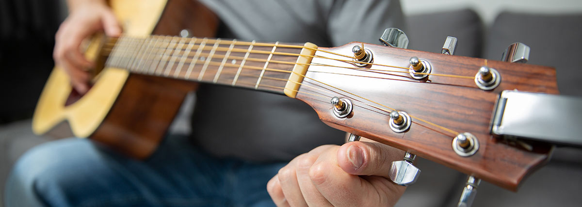 Close up of an acoustic guitar headstock showing how humidity can affect wood and tuning stability